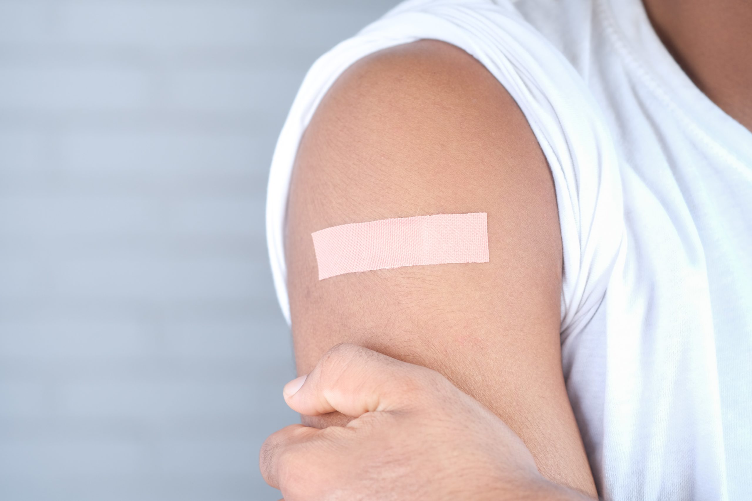 Bandage on arm representing parenting disputes around Covid-19 vaccine