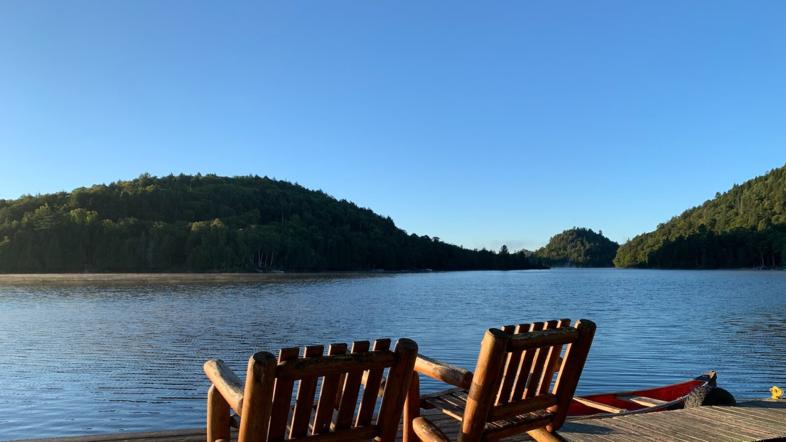 photo of two wooden chairs overlooking lake representing a family cottage property