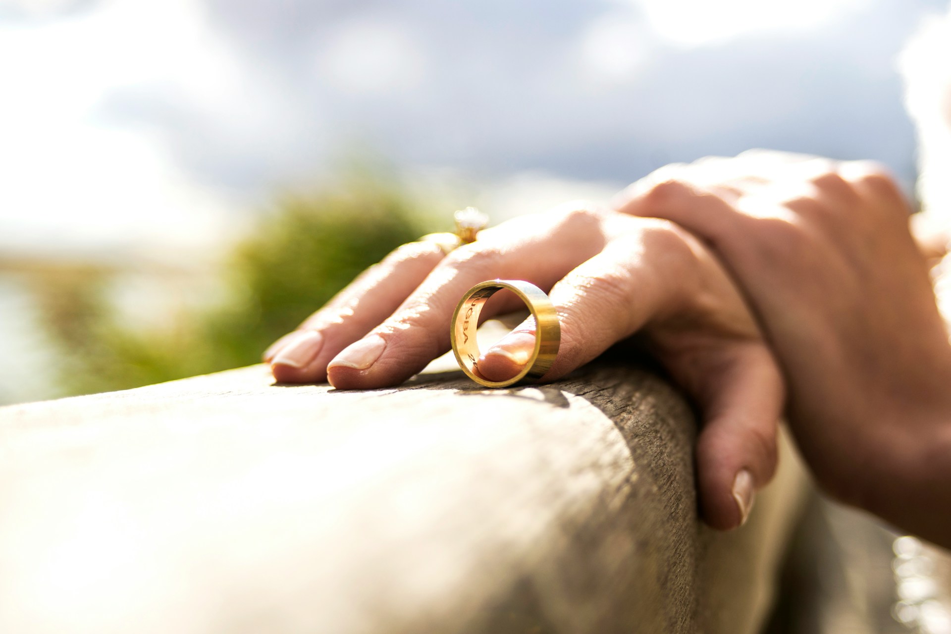 A person holding a gold ring while resting hand on ledge, representing separation and divorce in Ontario.
